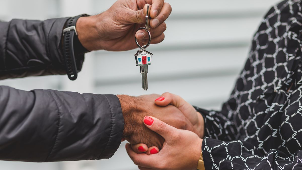 Agent immobilier remettant les clés à un client, symbole de réussite